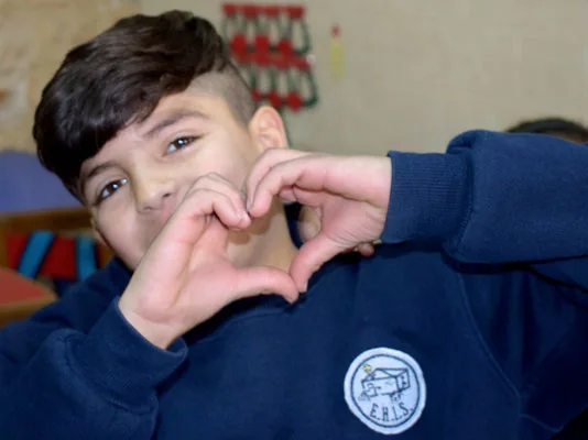 A teenager makes a heart during the workshop