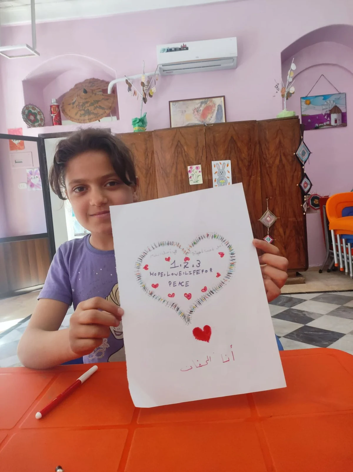Child showing a drawing for peace.