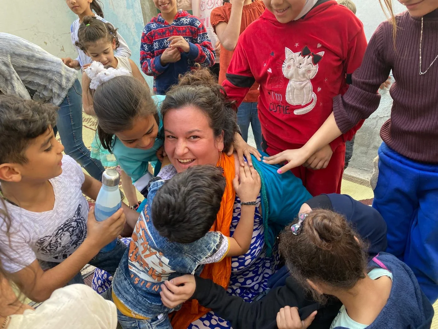 Soumaya Hallak surrounded by children during a 123 HOPE activity.